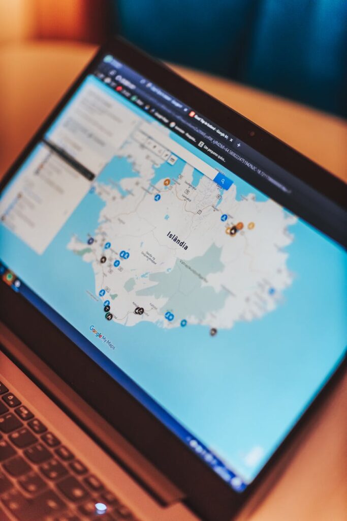 laptop with map on blue screen on table at home